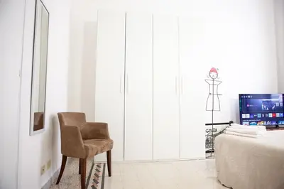a bedroom with a chair and a television at Il Viandante al Pigneto - Parcheggio privato su richiesta in Rome