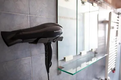 a hair dryer hanging on a wall next to a mirror at Il Viandante al Pigneto - Parcheggio privato su richiesta in Rome