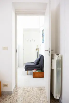 a doorway to a living room with a blue couch at Il Viandante al Pigneto - Parcheggio privato su richiesta in Rome