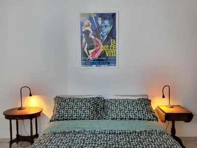 a bedroom with a bed with two lamps and a poster at Ginny's Home in Rome