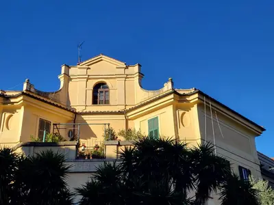 a yellow building with a window and a balcony at Ginny's Home in Rome