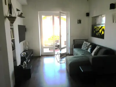 a living room with a couch and a glass door at Rooftop Appia antica,silenzioso riservato two bedrooms two bathrooms in Rome