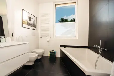 a bathroom with a tub and a toilet and a sink at Room In Roma Isole in Rome