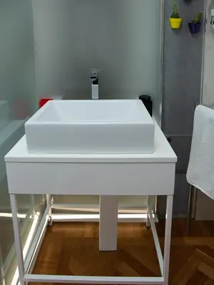 a white sink sitting on top of a table at Room In Roma Isole in Rome