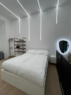 a white bedroom with a bed and a mirror at San Pietro love Apartament in Rome