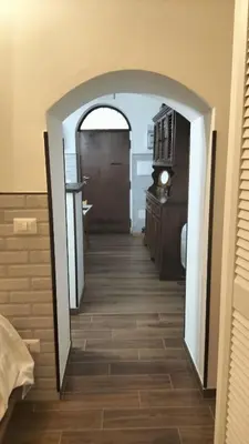 an archway leading to a hallway with a kitchen at Trastevere Heritage Suite in Rome