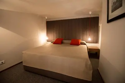 a bedroom with a large bed with two red pillows at Assunta Domus in Rome