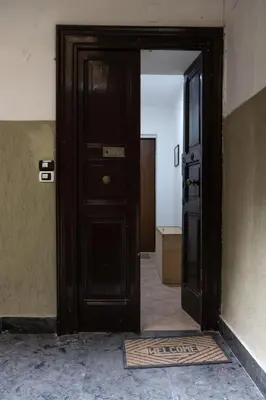 an open wooden door in a room with a mat at Casa Matteo53 Termini - Castro Pretorio in Rome