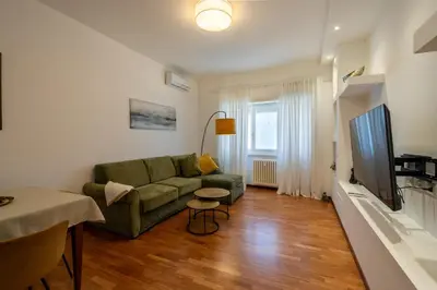 a living room with a green couch and a television at Kimera Luxury Apartments in Rome San Pietro in Rome