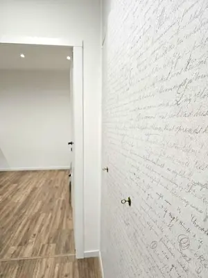 a hallway with a white brick wall and a door at Ricettiva Cipro San Pietro e Musei Vaticani in Rome