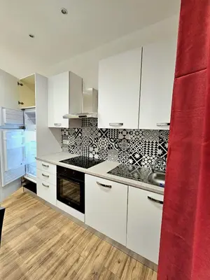 a kitchen with white cabinets and a stove top oven at Ricettiva Cipro San Pietro e Musei Vaticani in Rome