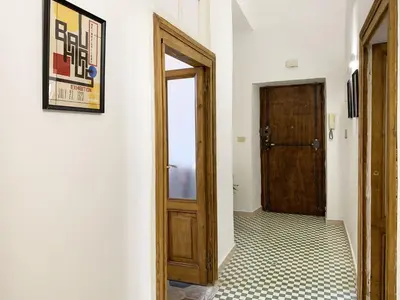 a hallway with a wooden door and a tile floor at RomeAsYouLike - Vatican Apartment N°73 in Rome