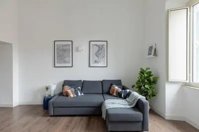 a living room with a blue couch and a window at iFlat Magnificent Central Apartment in Rome