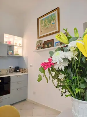 a kitchen with a vase of flowers on a table at Gianicolo Sweet Home in Rome