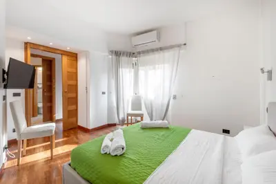 a bedroom with a green bed with towels on it at Vista Cupola San Pietro - Stazione Roma S Pietro in Rome