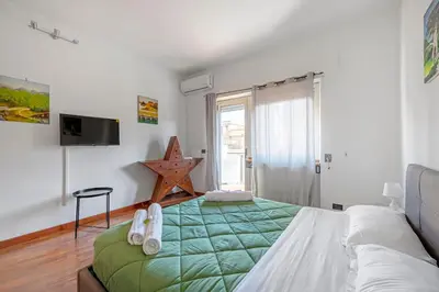 a bedroom with a bed with a green comforter at Vista Cupola San Pietro - Stazione Roma S Pietro in Rome