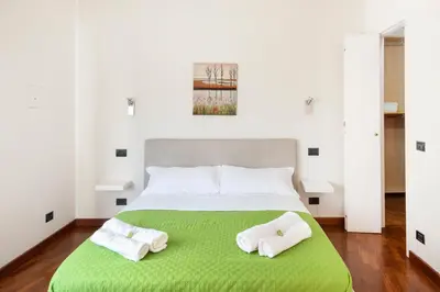 a bedroom with a green bed with two white towels at Vista Cupola San Pietro - Stazione Roma S Pietro in Rome