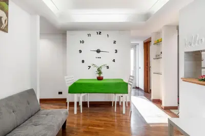 a living room with a green table and a clock at Vista Cupola San Pietro - Stazione Roma S Pietro in Rome