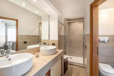 a bathroom with two sinks and a shower at Vista Cupola San Pietro - Stazione Roma S Pietro in Rome