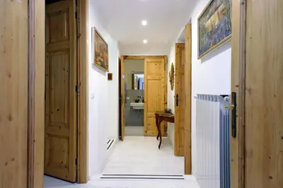 a hallway with wooden doors and a sink in a bathroom at TreasureRome Opera & Trevi Grand Suite 3BR in Rome