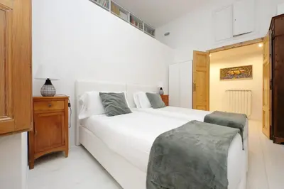 a bedroom with a white bed and a wooden cabinet at TreasureRome Opera & Trevi Grand Suite 3BR in Rome