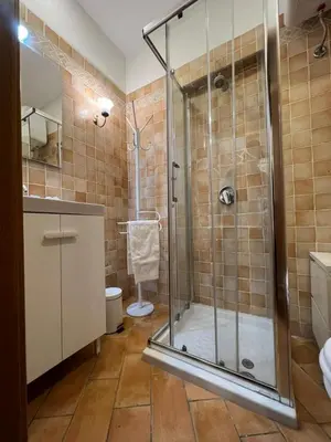 a bathroom with a glass shower with a toilet at Magenta Collection Panico 32 in Rome