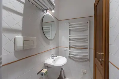 a small bathroom with a sink and a mirror at River61 - Guest House in Rome