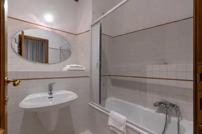 a bathroom with a sink and a tub and a mirror at River61 - Guest House in Rome