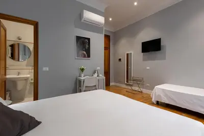 a bedroom with a white bed and a bathroom at River61 - Guest House in Rome