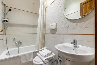 a bathroom with a sink and a toilet and a mirror at River61 - Guest House in Rome
