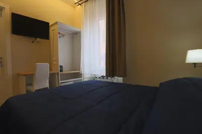 a bedroom with a bed and a desk and a television at Binario Zero in Rome