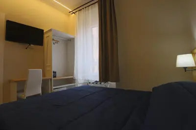a bedroom with a bed and a desk and a television at Binario Zero in Rome