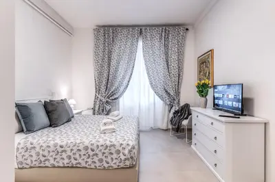 a bedroom with a bed and a dresser with a television at PMT Apt in Rome