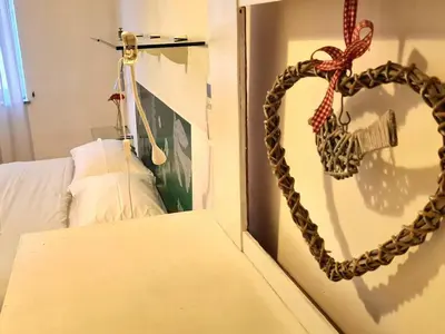 a heart hanging on a wall next to a bed at Gorgeous Flat In Pigneto in Rome