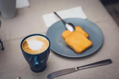 a cup of coffee next to a plate of food at Da Alessia Per Dormire Al Coppedé in Rome