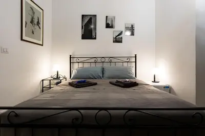 a bedroom with a large bed with two lamps at Da Alessia Per Dormire Al Coppedé in Rome