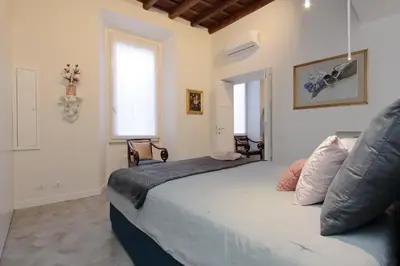 a bedroom with a large bed with two windows at Luxury apartment in Rione Monti in Rome