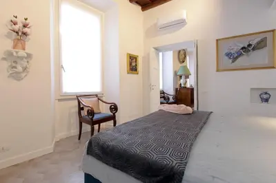 a bedroom with a bed and a window and a chair at Luxury apartment in Rione Monti in Rome