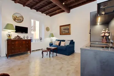 a living room with a blue couch and a tv at Luxury apartment in Rione Monti in Rome