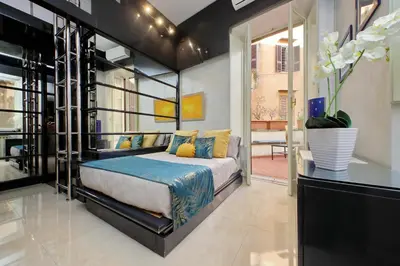 a bedroom with a bed and a large window at Charming loft with terrace at the Quirinale in Rome