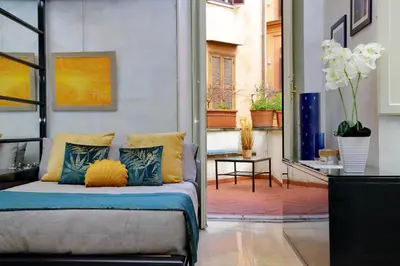 a room with a bed with pillows on it at Charming loft with terrace at the Quirinale in Rome