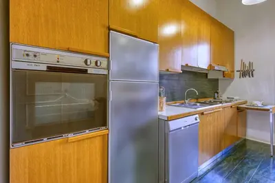 a kitchen with a stainless steel refrigerator and wooden cabinets at Vespasiano Luxury apartment for 4 in Rome