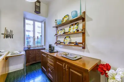 a kitchen with a wooden counter with plates on the shelves at Vespasiano Luxury apartment for 4 in Rome