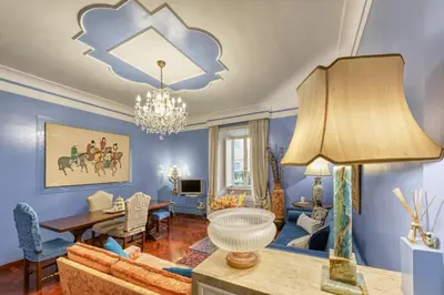 a living room with blue walls and a dining room at Vespasiano Luxury apartment for 4 in Rome