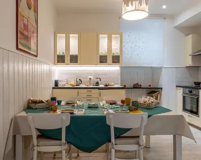 a kitchen with a table with a green table cloth at Rainbow Vatican home in Rome