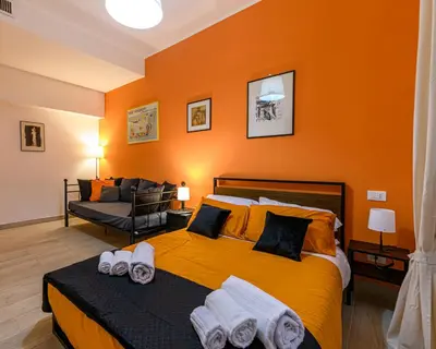 a bedroom with a large yellow bed with towels on it at Rainbow Vatican home in Rome