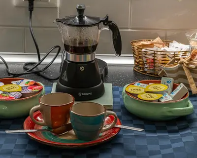 a blender on a counter with two cups on a plate at Rainbow Vatican home in Rome