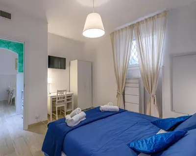 a bedroom with a blue bed with two towels at Rainbow Vatican home in Rome