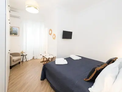 a white bedroom with a bed and a living room at Casa TPZ Metro Baldo - Close To Vatican in Rome