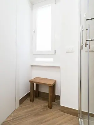 a small wooden bench in a room with a window at Casa TPZ Metro Baldo - Close To Vatican in Rome